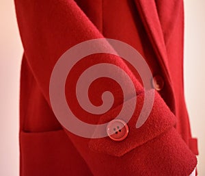 Red wool coat sleeve with plastic button