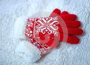 Red woolen mittens on a white background.