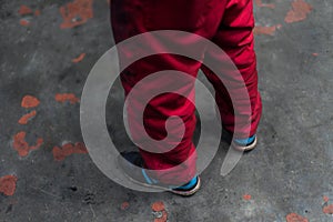 Red workwear pants on grunge concrete background photo