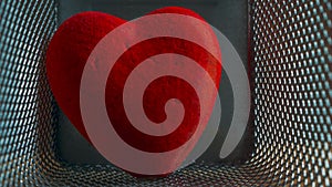 Red Wounded Velvet Heart in a Mesh Cage. Love, Home Violence, Loneliness, Freedom and Heartache Concept