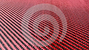 Red woven Black carbon fiber composite material background close up view