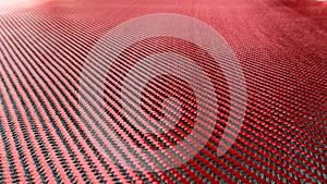 Red woven Black carbon fiber composite material background close up view