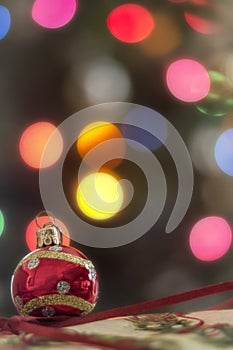 Red Xmas Ornament in front of Xmas tree lights