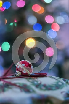 Red Xmas Ornament on present by tree