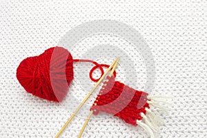 Red yarn ball like a heart on the white crochet background. Romantic Valentines Day concept. Red heart made of wool yarn with plac