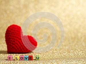 Red yarn heart with I Love You text from bead colorful on the gold floor and background copy space for text. Valentines day, love
