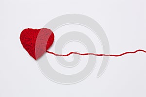 Red yarn heart isolated on white.