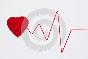 Red yarn heart with thread like ECG pattern