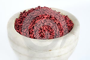 Red yeast fermented rice or kojic riceRed yeast fermented rice on mortar grinding bowl