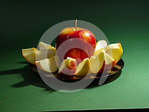 Red yellow apple and slice isolated on green background