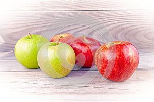 Red and yellow apples on wooden boards.