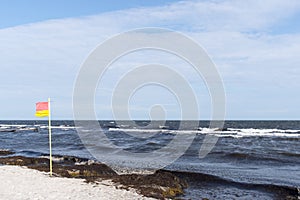 Red and yellow beach flag flapping in the breeze