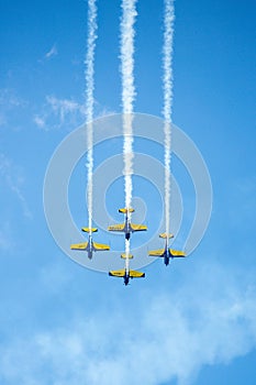 Red, yellow and blue airplanes performing stunts in the air. Aerobatics airplane formation on a clear sunny sky. photo