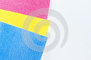 Red yellow and blue sponge cleaning cloths close up on a white background