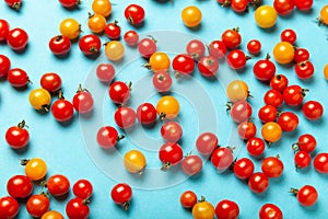 Red and yellow cherry tomatoes on blue background. Fresh bright organic vegetables