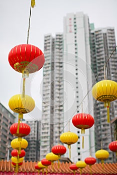 Red and yellow Chinese lanterns on a background of white skyscrapers. concept of contrast of old traditions and modern world