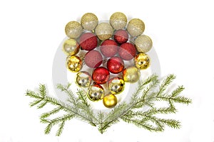 Red yellow Christmas tree balls in the form of a heart with green spruce branches isolated on a white background. Toys, New year