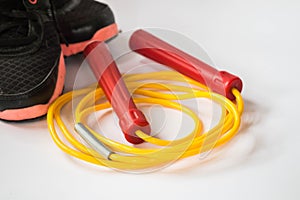 Red and yellow color jump rope with sport shoe