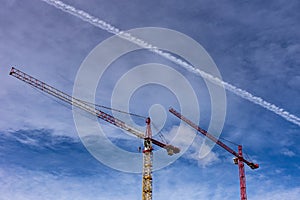 Red and yellow cranes on blue sky