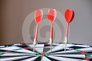 Red and yellow dart arrows hitting in the target center of dartboard. Success hitting target aim goal achievement concept