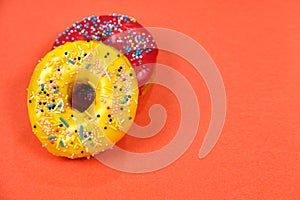 Red and yellow donuts on a pink background, space for text