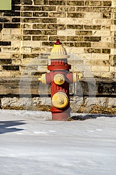 Red and Yellow Fire Hydrant in Front of an Old Brick Building