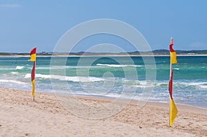 Red and yellow flags on patrolled beach indicating safe to swim area