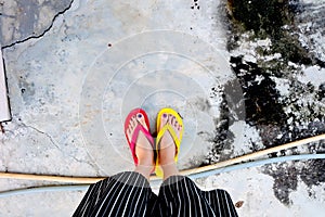 Red and Yellow Flip Flops. Selfie Woman Wearing Flip Flop Standing on Cement Background