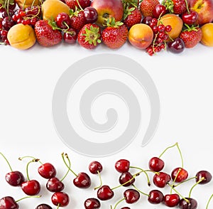 Red and yellow fruits on white background. Ripe apricots, red currants, cherries and strawberries. Sweet and juicy fruits at bord