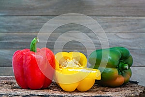 Red, yellow and green bell pepper Capcicum.  on wooden with brown background