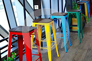 Red yellow green and blue chairs stand by the window, colorful vintage style furniture