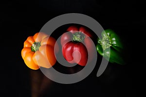 Red yellow green pepper on a black table