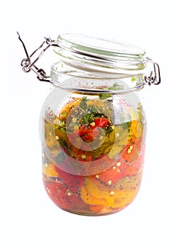 Red, yellow and green peppers in a jar.