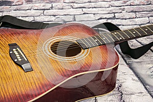 A red and yellow guitar with stripes lies on a wooden background