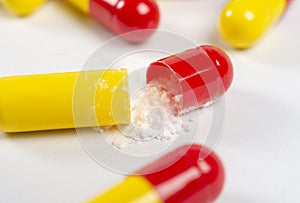 red and yellow open pills on white background, health and nature, top view, copy space