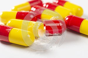 red and yellow open pills on white background, health and nature, top view, copy space