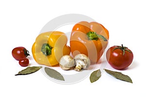 Red yellow and orange peppers with tomatoes on a white background.