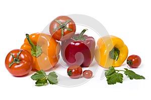 Red yellow and orange peppers with tomatoes on a white background.