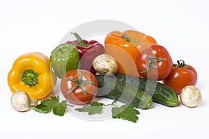 Red yellow and orange peppers with tomatoes on a white background.
