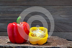 Red and yellow peppers bell pepper or Capcicum.  on wooden with brown background