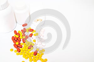 Red, Yellow,Pink tablets and white medicine bottles