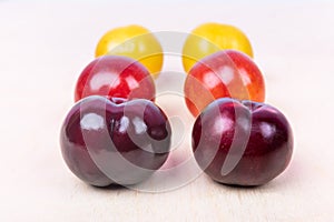 Red, yellow plum fruit close up on the white background