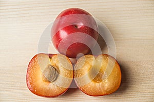 Red and yellow plums on wooden cutting board photo