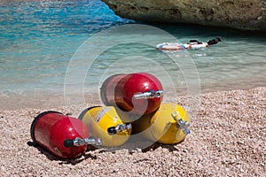 Red and Yellow Scuba Oxygen Tanks for Divers on a Beach