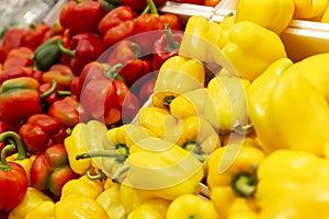 Red and yellow sweet peppers on the counter in a store. Vegetarianism, healthy foods and vitamins. Close-up