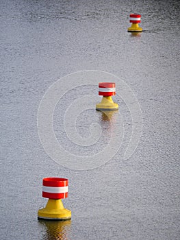 Red-yellow-white buoys drifting on a river