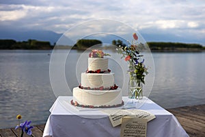 redberries wedding cake with flowers in a lake landscape