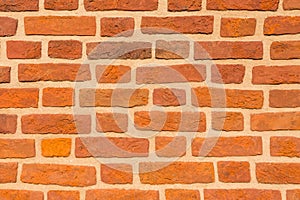 Reddish brick wall close up for background in natural summer light