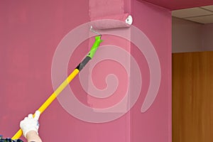 Redecorating. Painting walls with paint-roller