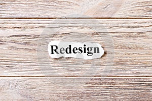 REDESIGN of the word on paper. concept. Words of REDESIGN on a wooden background